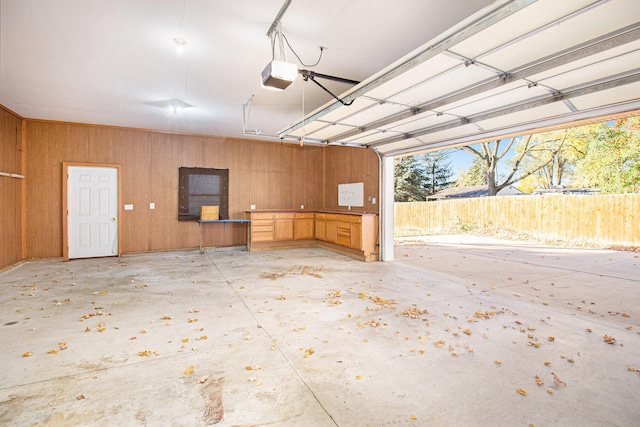 garage with wood walls and a garage door opener