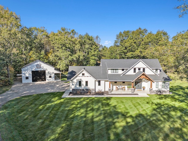 view of front of home with a front yard, an outdoor structure, and a garage