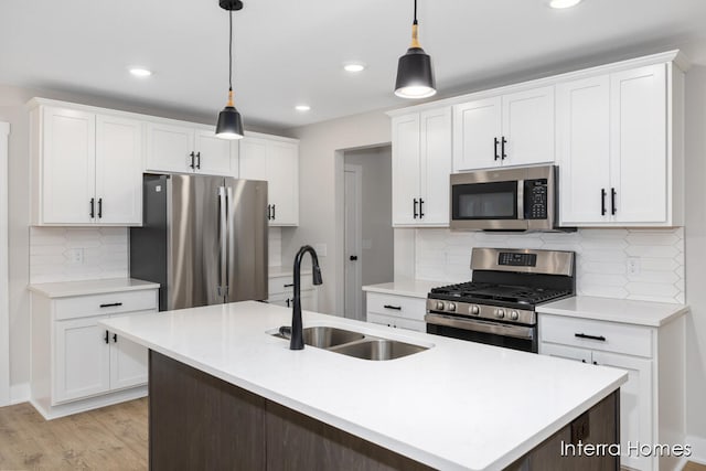 kitchen with white cabinetry, pendant lighting, stainless steel appliances, and sink