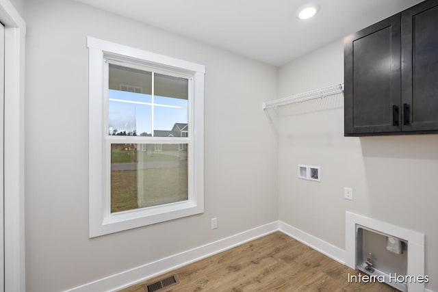 laundry area featuring washer hookup, cabinets, and hardwood / wood-style flooring