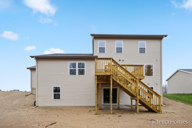 rear view of house featuring a wooden deck