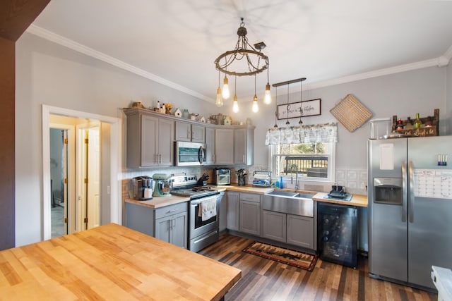 kitchen featuring dark hardwood / wood-style flooring, stainless steel appliances, sink, pendant lighting, and gray cabinets