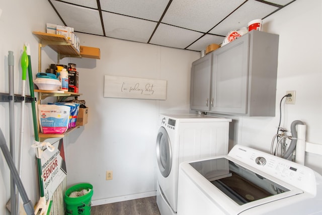 laundry area featuring cabinets, dark hardwood / wood-style flooring, and washing machine and clothes dryer