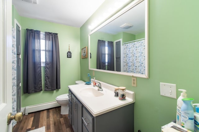 bathroom with hardwood / wood-style floors, vanity, toilet, and a baseboard heating unit