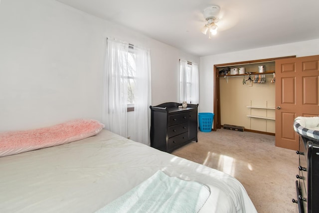 carpeted bedroom featuring ceiling fan and a closet