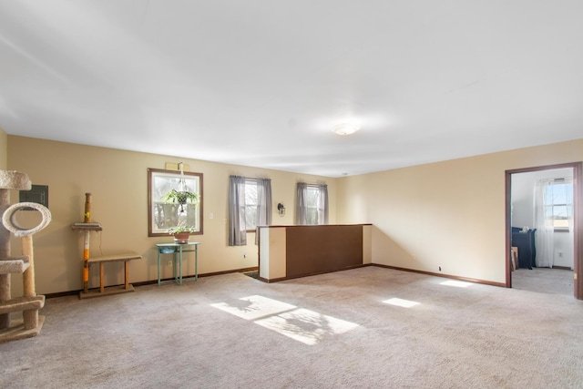 interior space featuring light colored carpet and a healthy amount of sunlight