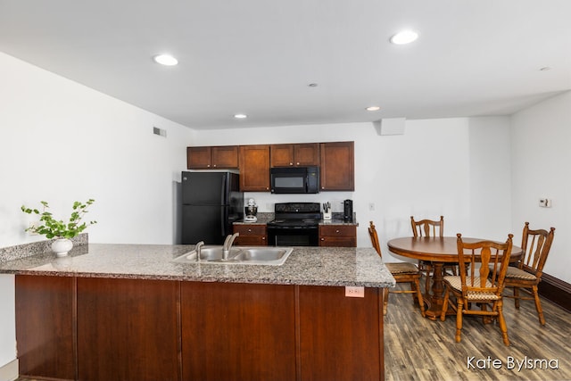 kitchen featuring kitchen peninsula, black appliances, sink, and dark hardwood / wood-style flooring