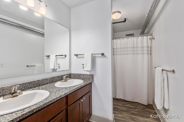 bathroom featuring wood-type flooring, a shower with shower curtain, and vanity