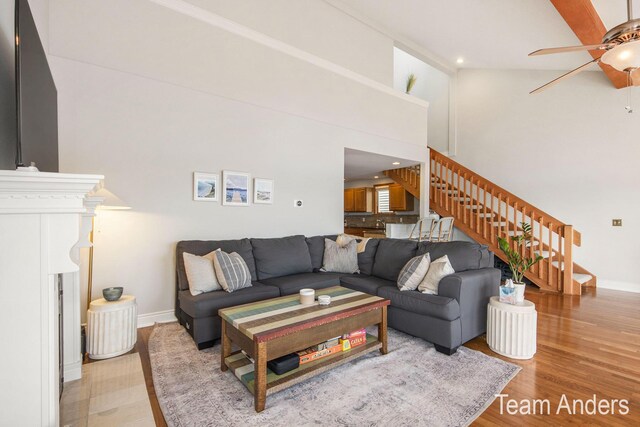 living room with light wood-type flooring, high vaulted ceiling, and ceiling fan