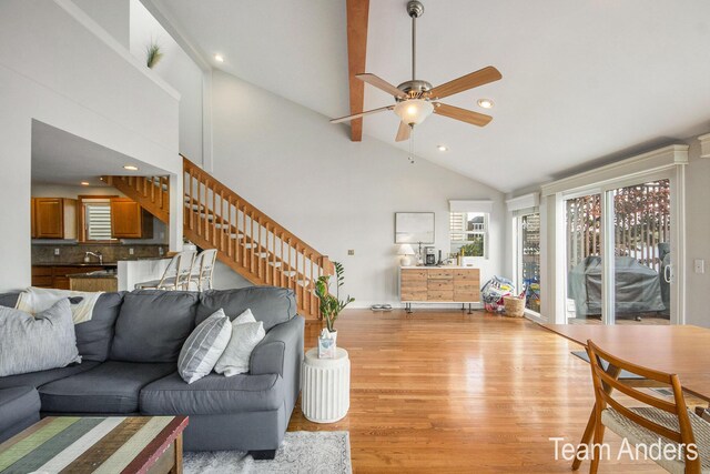 living room featuring light hardwood / wood-style flooring, high vaulted ceiling, and ceiling fan