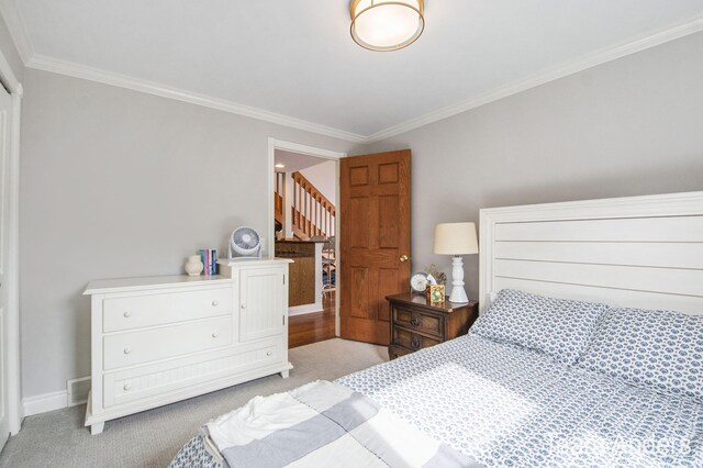 bedroom with light colored carpet and ornamental molding