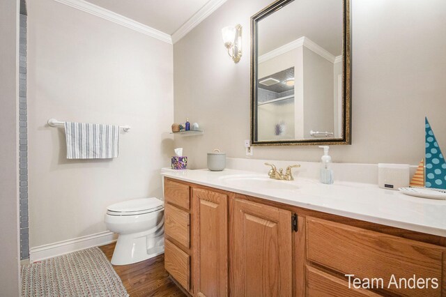 bathroom featuring wood-type flooring, an enclosed shower, toilet, vanity, and ornamental molding