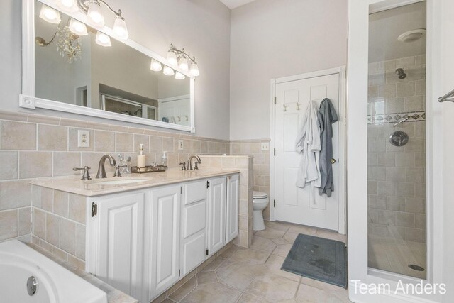 full bathroom with vanity, tile walls, tile patterned flooring, a chandelier, and toilet