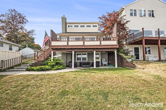 rear view of property with a lawn, a patio, and a deck