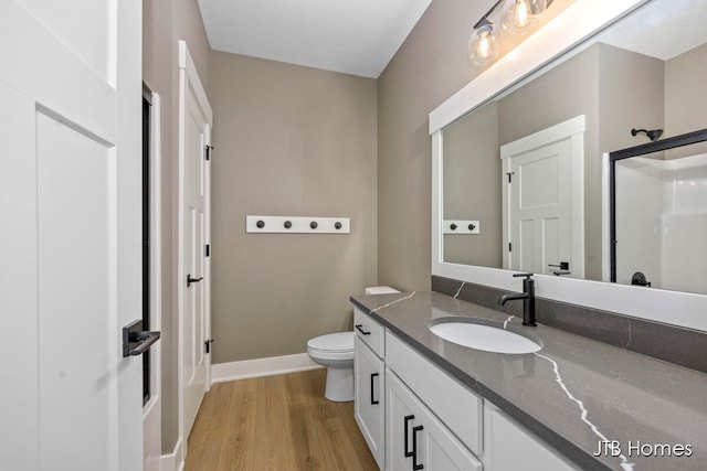 bathroom with hardwood / wood-style floors, vanity, and toilet