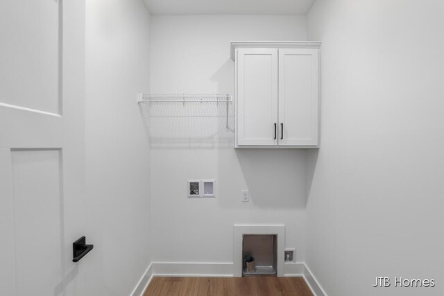 washroom featuring cabinets, wood-type flooring, and hookup for a washing machine