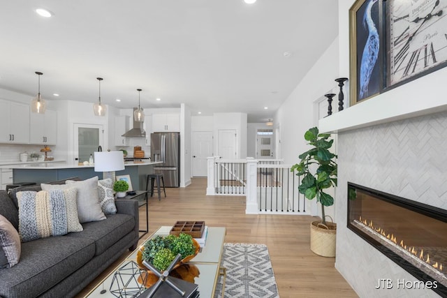 living room with light hardwood / wood-style floors and a tiled fireplace