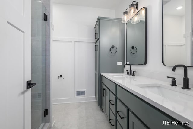 bathroom featuring a shower with door and vanity