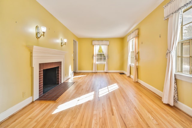 unfurnished living room with light hardwood / wood-style flooring and a fireplace