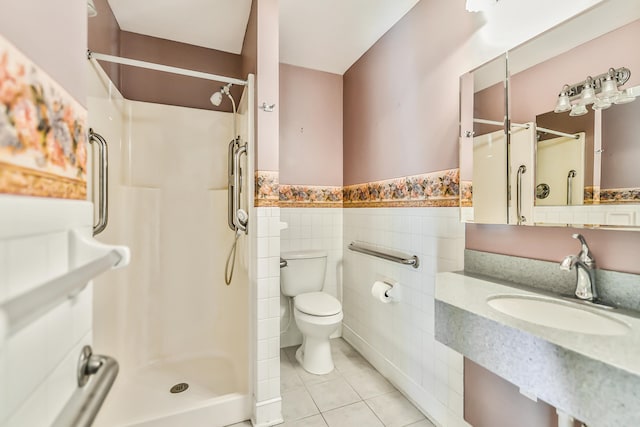 bathroom with tile patterned floors, toilet, sink, tile walls, and walk in shower