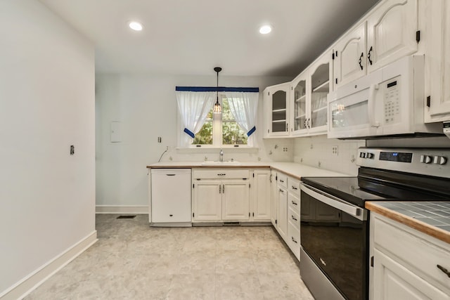 kitchen featuring white appliances, sink, tile countertops, backsplash, and pendant lighting