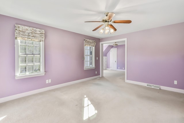 carpeted spare room featuring ceiling fan and a healthy amount of sunlight