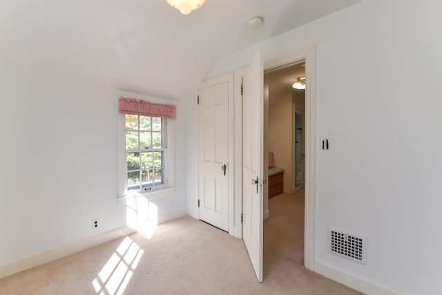 interior space featuring lofted ceiling and light colored carpet