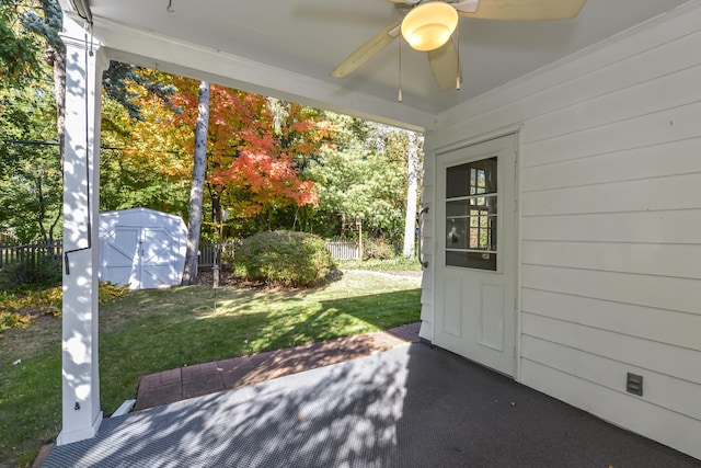 view of patio with ceiling fan and a storage unit