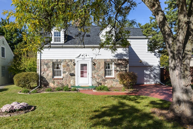 cape cod-style house featuring a front yard and a garage