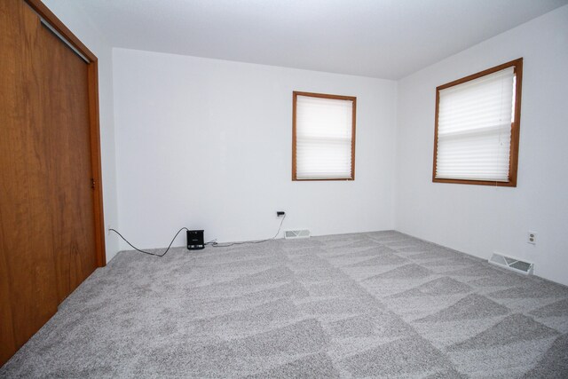 carpeted spare room featuring visible vents