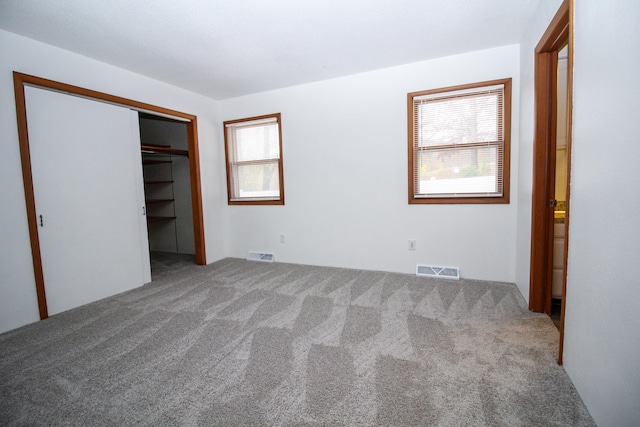 unfurnished bedroom featuring a closet, carpet flooring, and visible vents