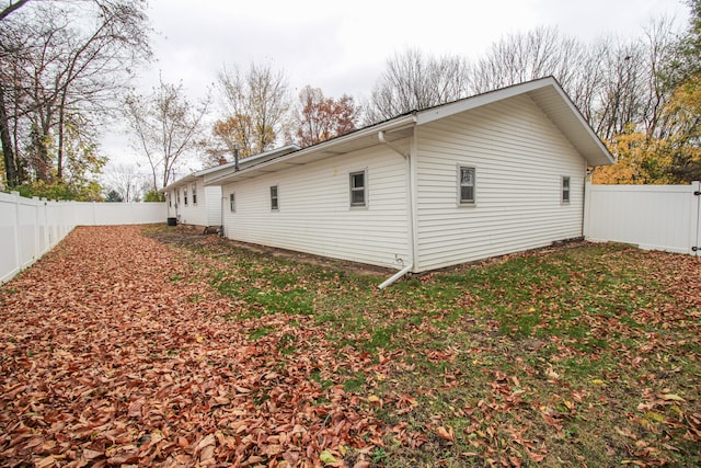 view of side of home with a lawn and a fenced backyard