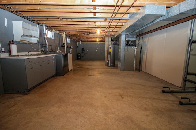 below grade area featuring washer / dryer, water heater, and a sink