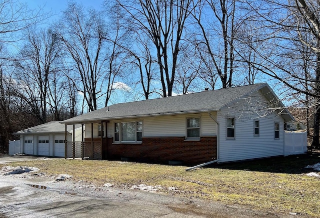 view of property exterior with driveway, brick siding, and an attached garage