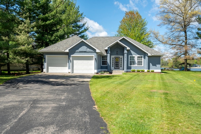 ranch-style home with a garage and a front lawn