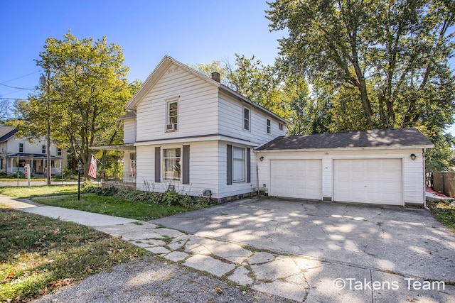 view of property featuring a garage and a front lawn