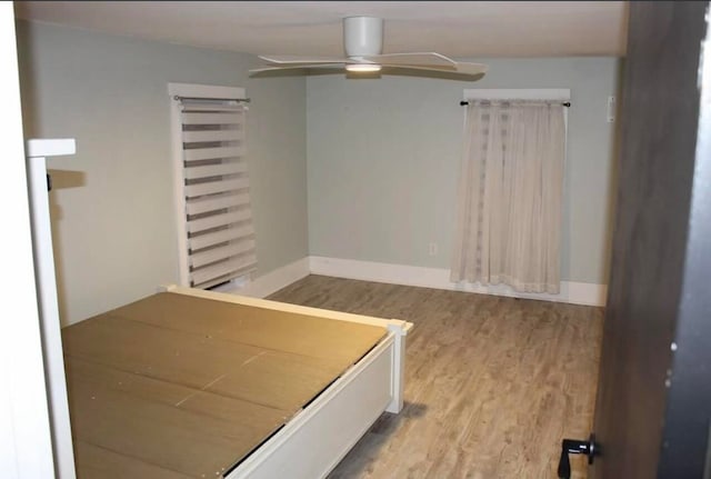 unfurnished bedroom with ceiling fan and wood-type flooring