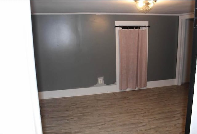 spare room featuring wood-type flooring and ornamental molding