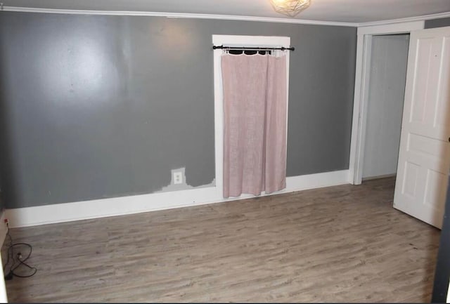 spare room with light wood-type flooring and ornamental molding