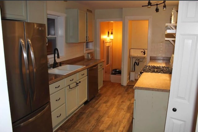 kitchen with hardwood / wood-style flooring, decorative backsplash, sink, and stainless steel appliances