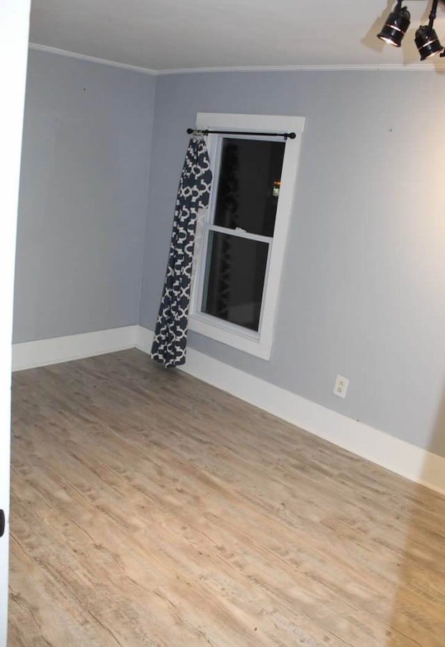 unfurnished room featuring crown molding and light hardwood / wood-style flooring