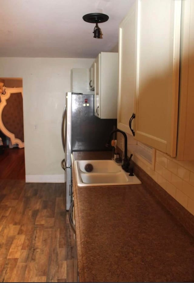 kitchen featuring dark hardwood / wood-style flooring, backsplash, and sink