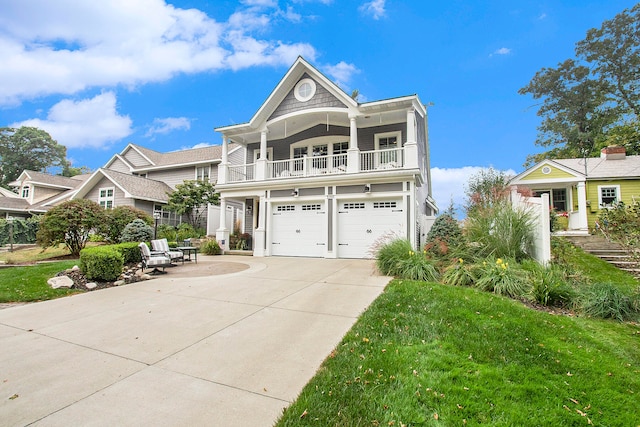 view of front of house featuring a balcony, a garage, and a front lawn