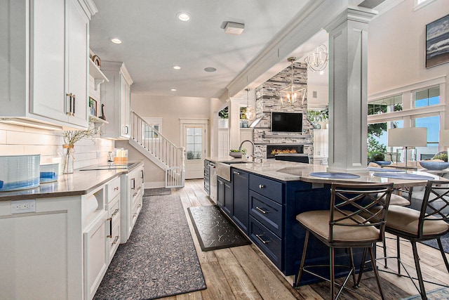 kitchen with white cabinets, light wood-type flooring, and a healthy amount of sunlight