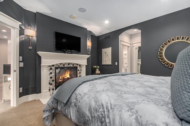 carpeted bedroom with a fireplace