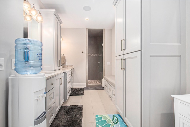 bathroom featuring vanity, a tile shower, and tile patterned floors