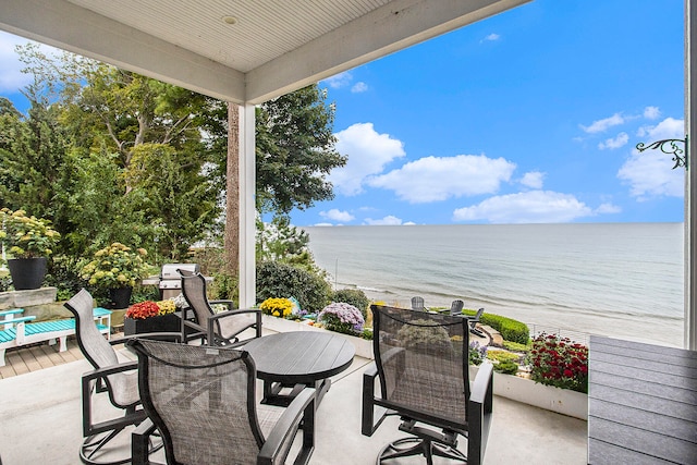 view of patio featuring a water view and a beach view