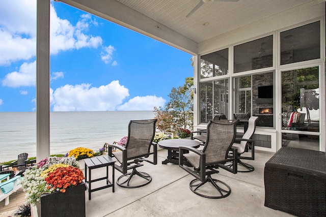 view of patio with a sunroom and a water view