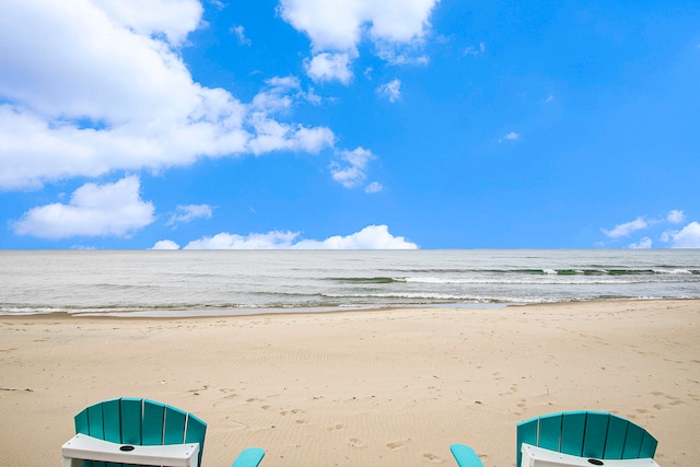 view of property's community featuring a water view and a beach view