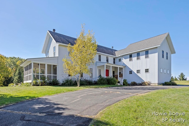 view of front of home featuring a front yard and a sunroom